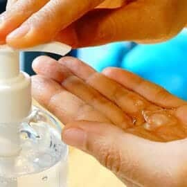 A woman pumping CBD hand sanitizer into the palm of her left hand.