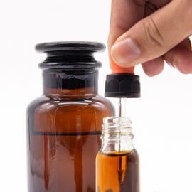 A bottle of pure CBD oil being extracted by a small dropper.